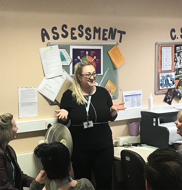 Rachel stood speaking to social workers.