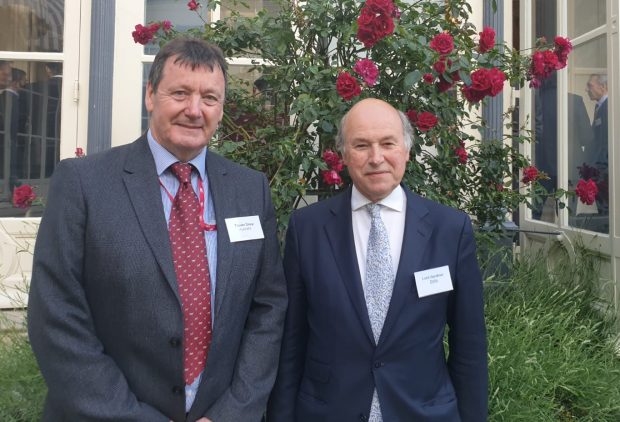 Two gentlemen in suits looking into camera for a photo