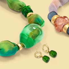 Jewellery by Chama Navarro Close ups of a colourful necklace, a bracelet, and a pair of earrings, all made with blown glass.