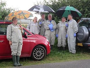 The bee inspectors and the UKAS assessment team sheltering from the rain