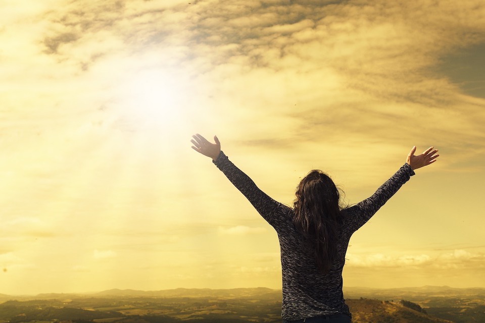 Image of person embracing the sunrise