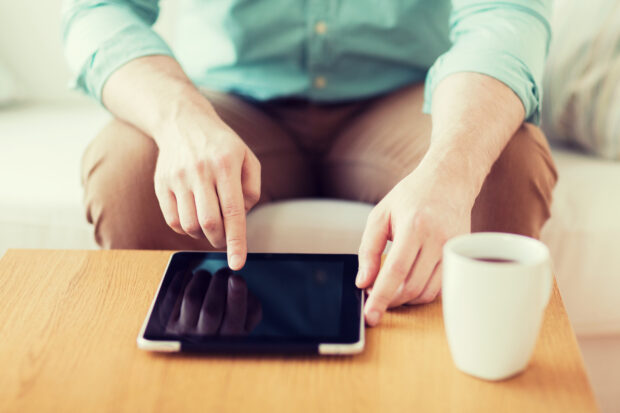 Close up of man with laptop and cup at home