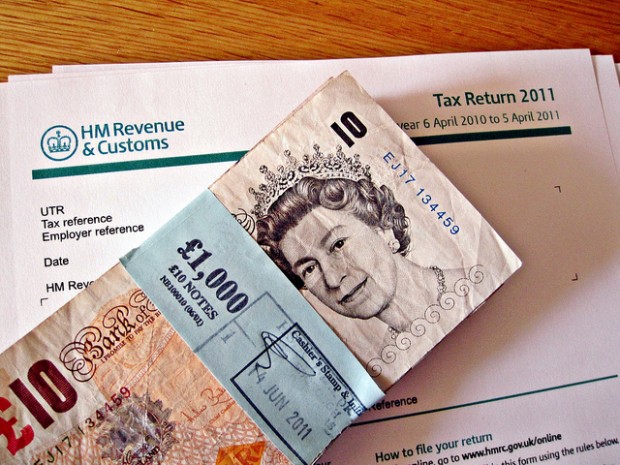 Photo of £1000 cash on top of a 2011 HMRC tax return form