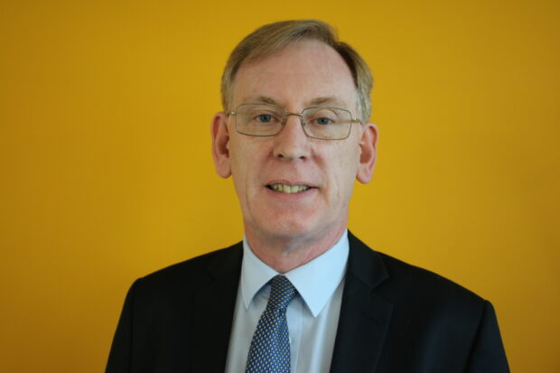Image of Alan Eccles stood in front of yellow wall