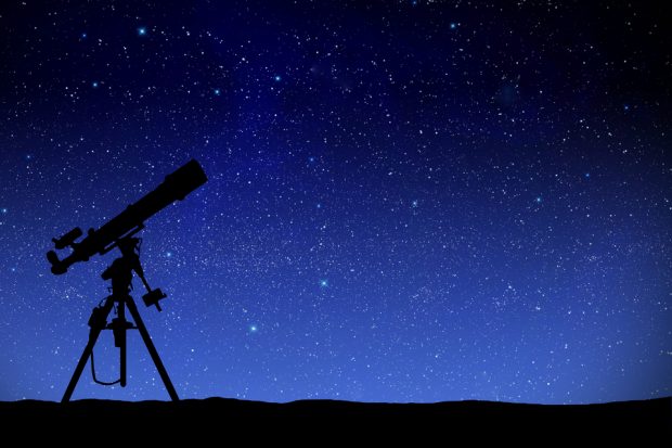 A telescope in front of the night sky