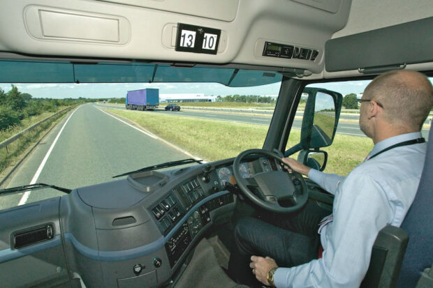 Lorry driver in side his cab on a motorway slip road