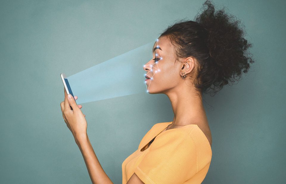 Woman scans face with mobile phone.