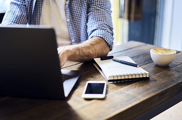 A man sitting at a desk in front of a laptop