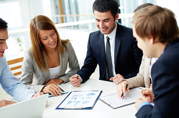 Business partners discussing documents at meeting.