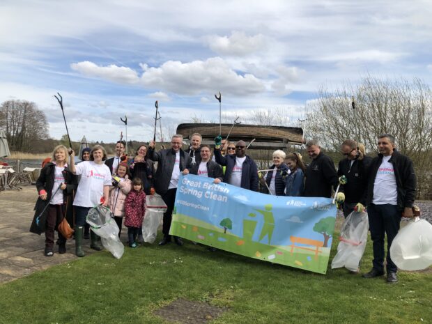 Image of Environment Secretary and a group of people holding a banner which says 'great british spring clean'