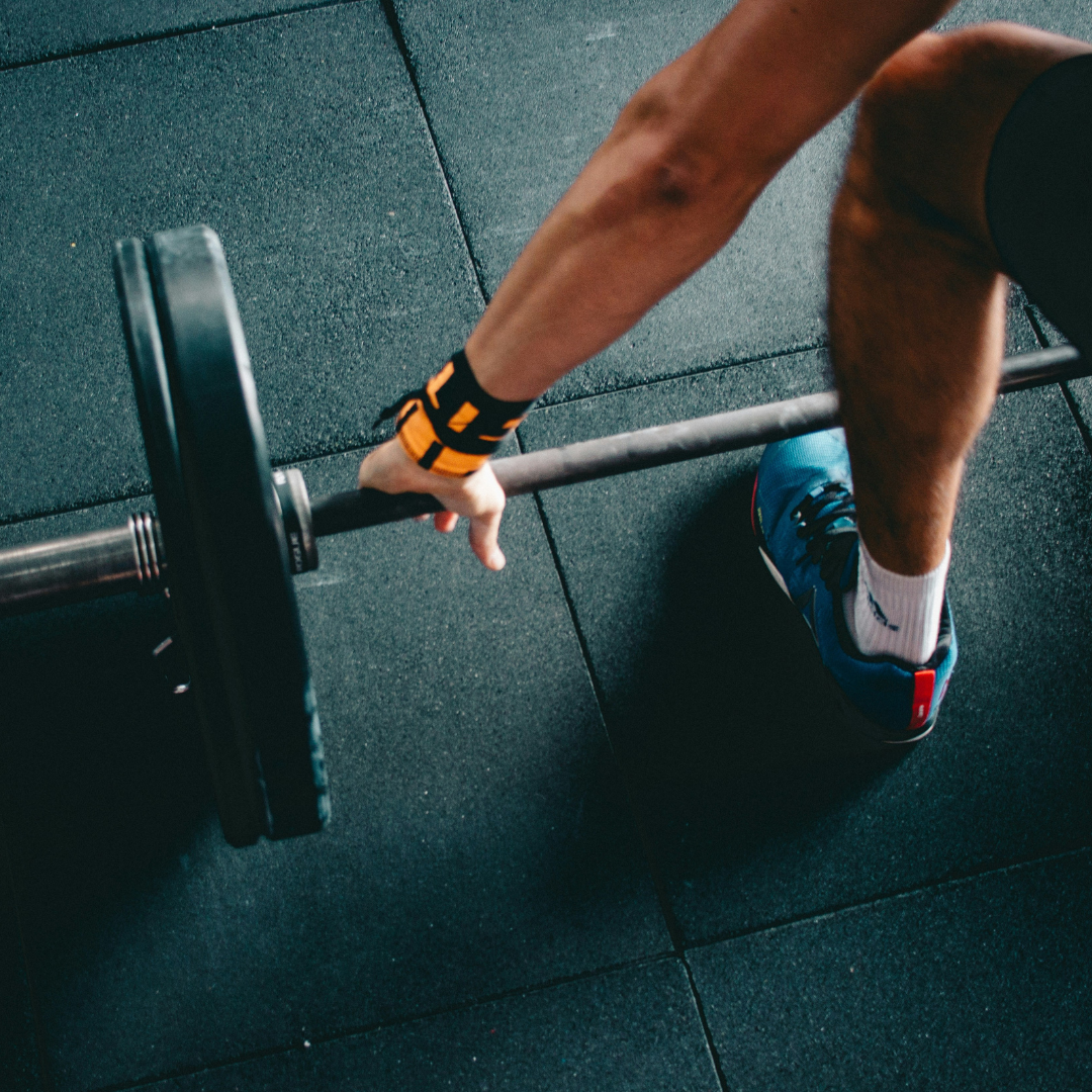 Person squatting down to pick up a barbell