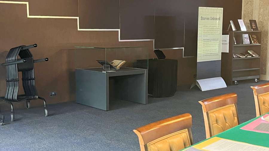 Display case next to a display board and in front of a green table.