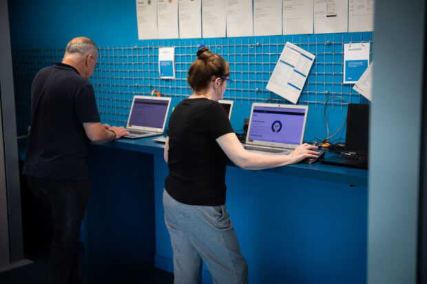 Man and woman in front of laptops in an office.