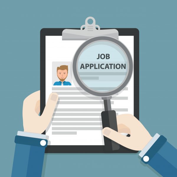 Businessman looking at job application with magnifying glass