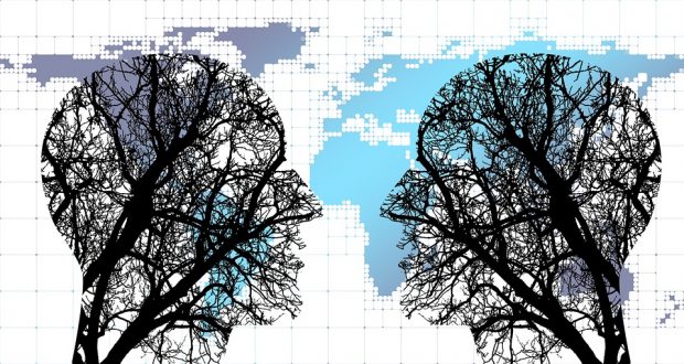 Two heads silohetted against a world map engaged in conversation