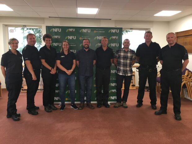 A group of police officers stand together in a conference room