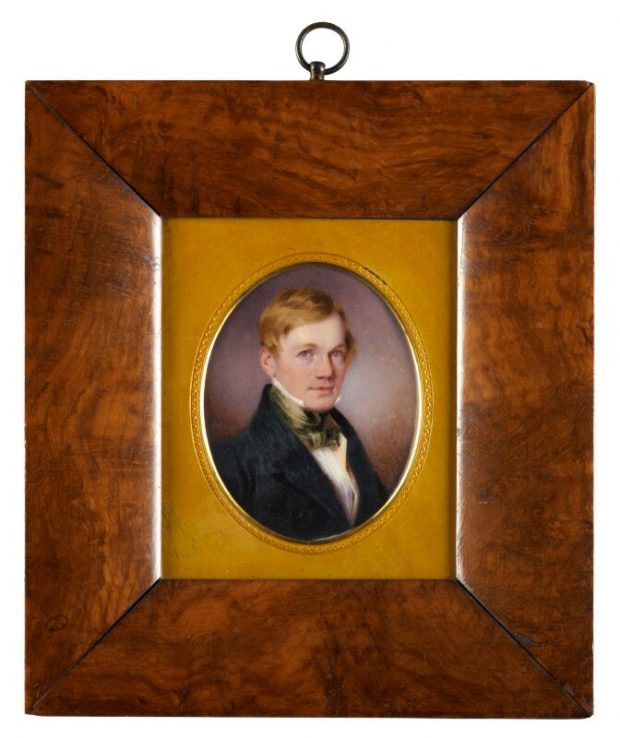 A portrait of Bennet Woodcroft in a wooden frame with yellow insert