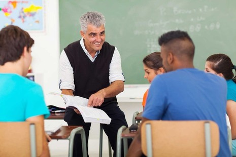 A teacher with some students in a school classroom
