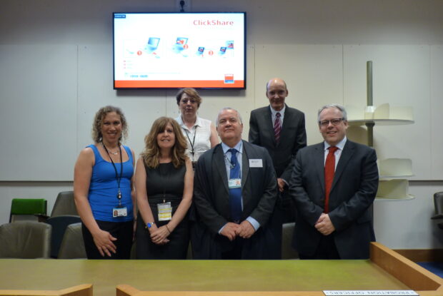 Group of people standing in front of plasma screen