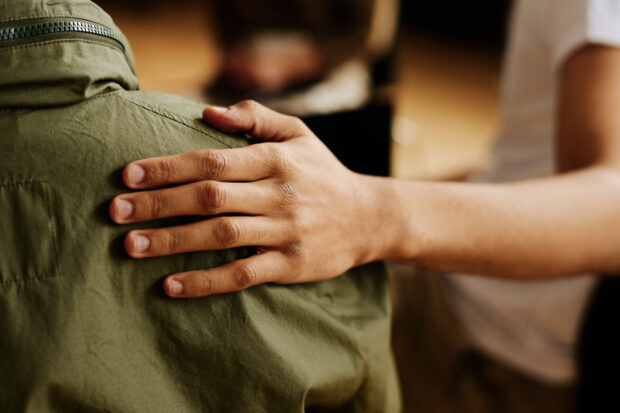Hand of young supportive person supporting colleague