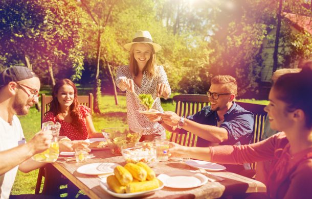 Happy friends having dinner at summer garden party