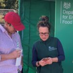 Becky Briggs, engagement team member, showing event attendee how to sign up to the Farming blog.