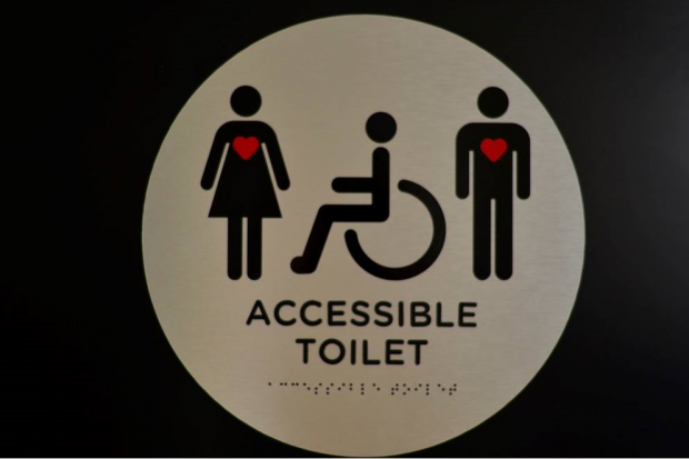 Image shows a female, a person in a disabled access vehicle and a male.i