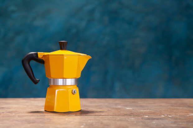 orange moka pot on wooden table