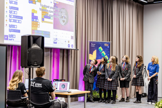 Pupils attend DVLA's 2026 Code Challenge event, presenting on stage