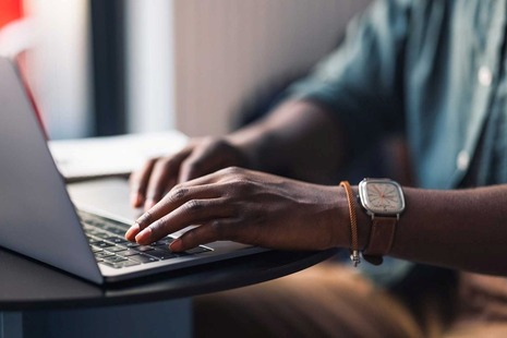 A person typing on a laptop computer