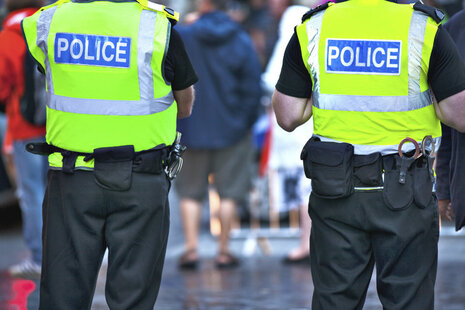 Two police officers from behind.