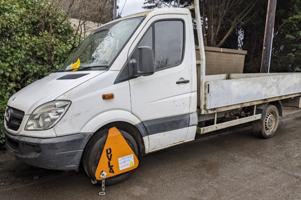 A white truck with a DVLA clamp on it.