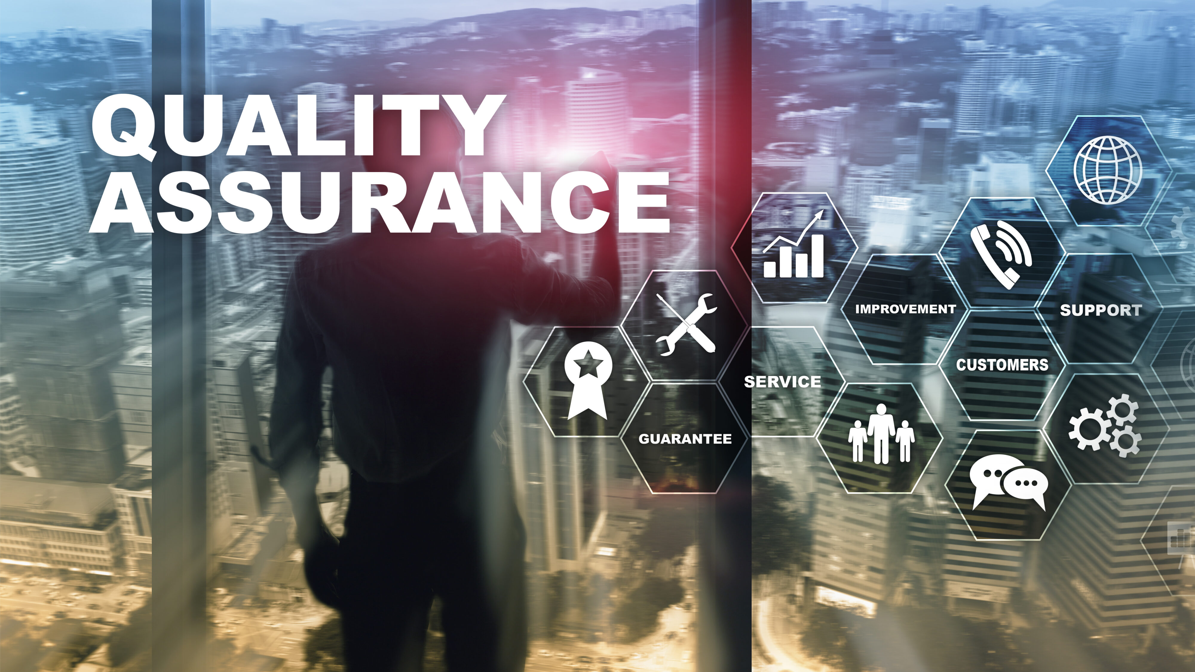 Man standing at a windwo overlooking a cityscape. Behind him are the words 'Quality Assurance'. Credit: Shutterstock.