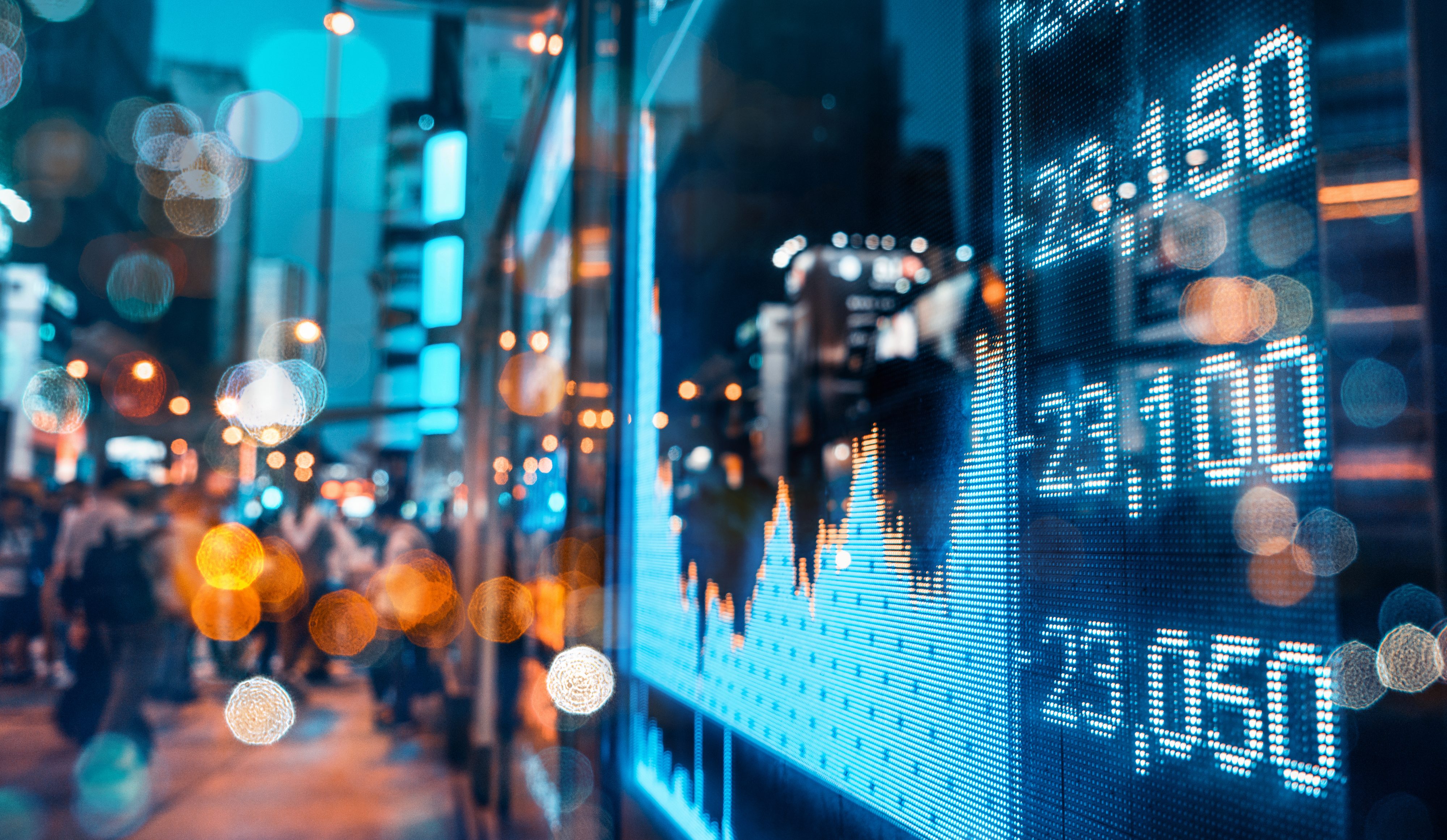 Out of focus image of tall buildings and stock market numbers