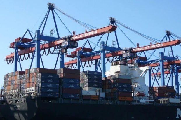 Large cranes load a container ship