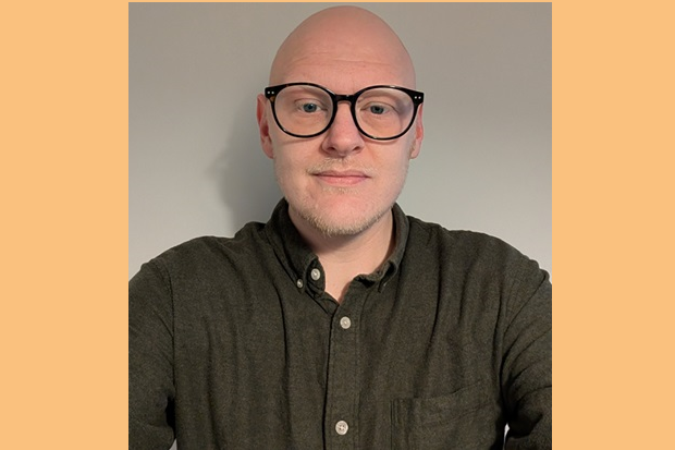 A person wearing glasses and a green shirt