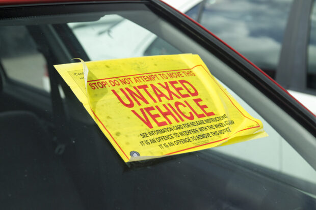 car winscreen with an untaxed vehicle sticker attached
