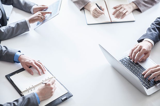 People in a meeting using tablets and laptop.