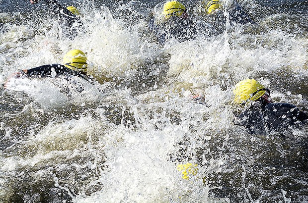 Image of swimmers in rough open water.