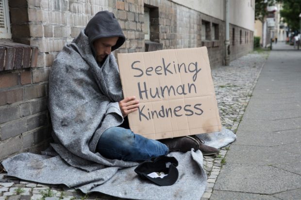 Man begging on the street - seeking human kindness