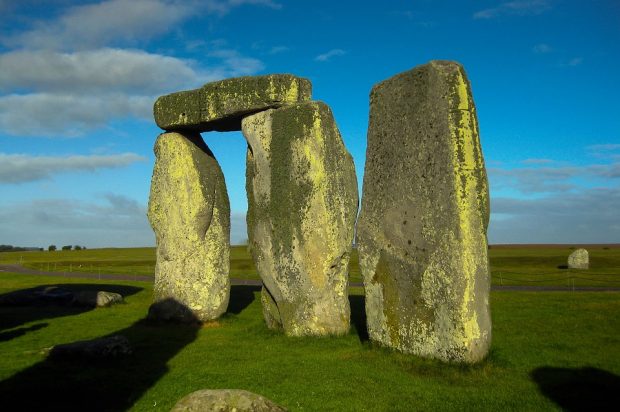 Image shows stones placed next to each other with one on top of a rock in the middle of a field.