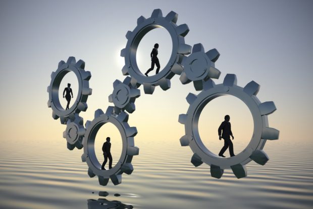 Individuals rotating cogs so they work together and move