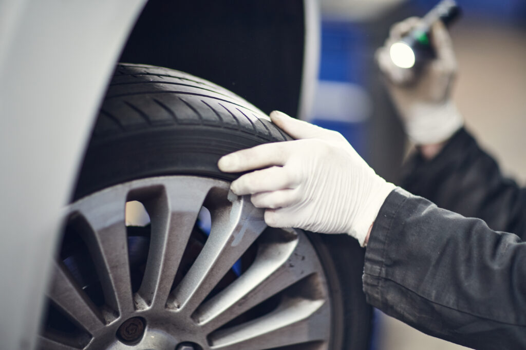 Close up of a person checking a tyre.