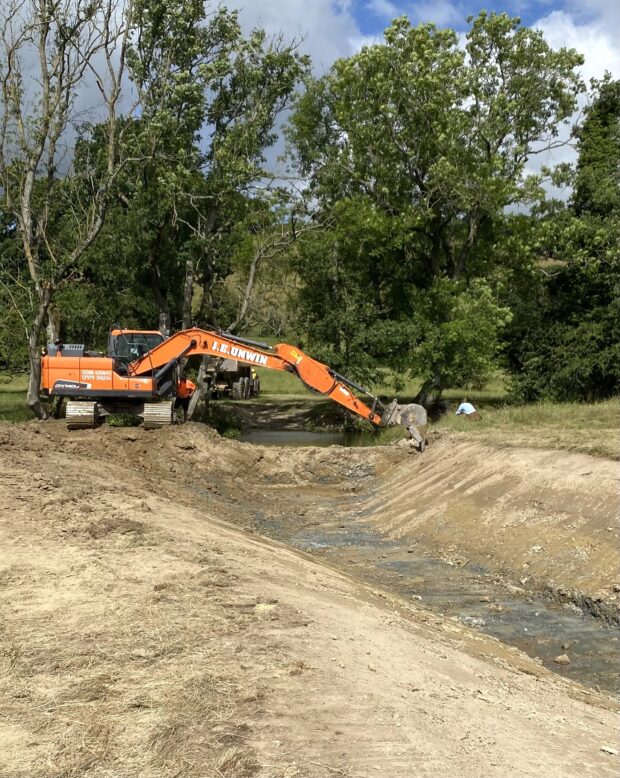 Digger about to break through bund and reconnect river