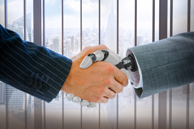 Cropped image of businessman dealing with robot against room with large window looking on city
