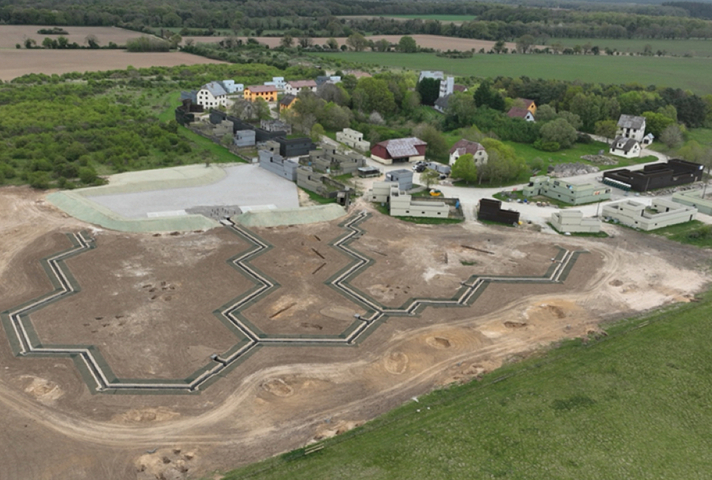 Aerial view of a new trench system, with buildings to the right.