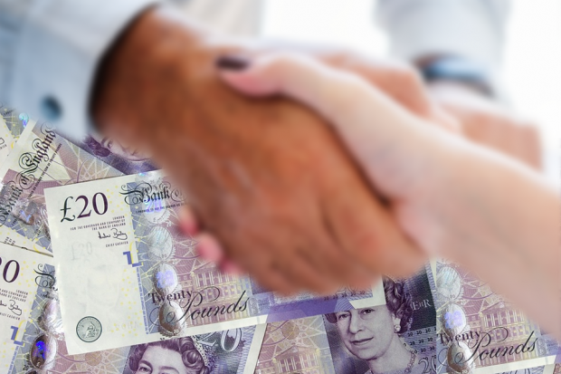 Two people shaking hands with lots of £20 notes in the background.