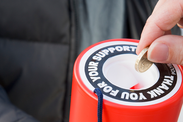 Person putting money in a collection tin.