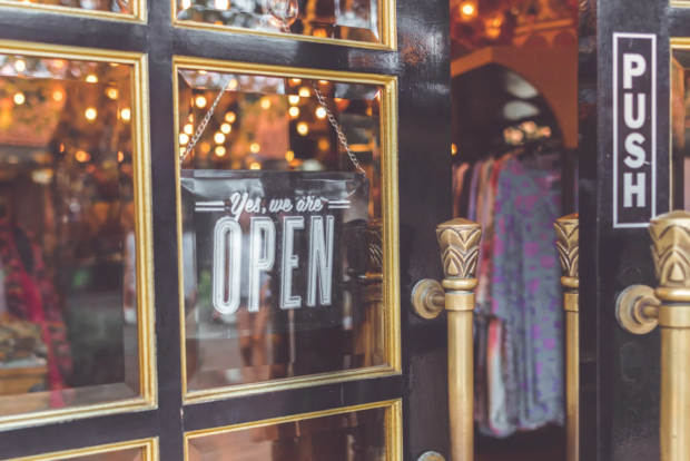 A business confirms it is open with a sign in its door.