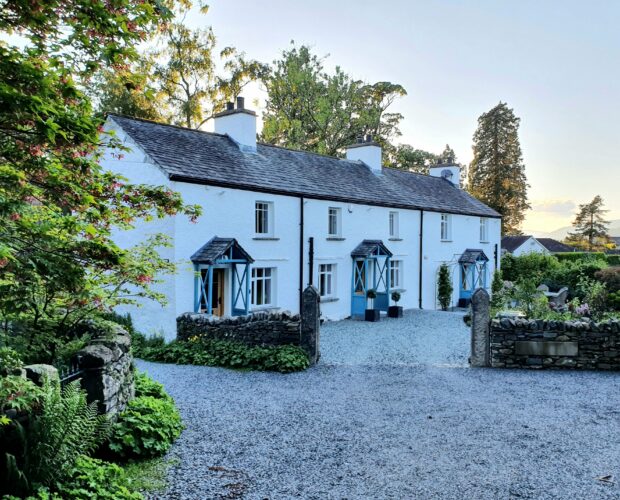 Terraced Cottages in English Lake District. Three white houses in a row with blue doors.